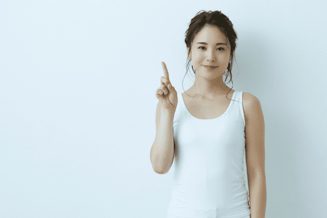 人差し指を上に上げる女性