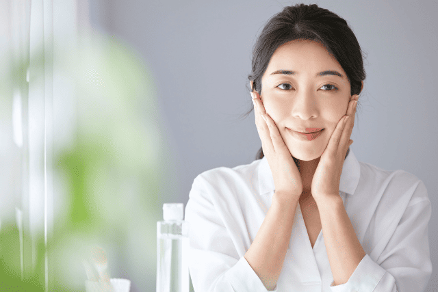 手のひらを顔に添えている女性