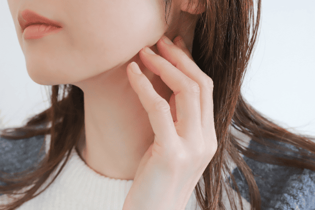 フェイスラインを抑える女性
